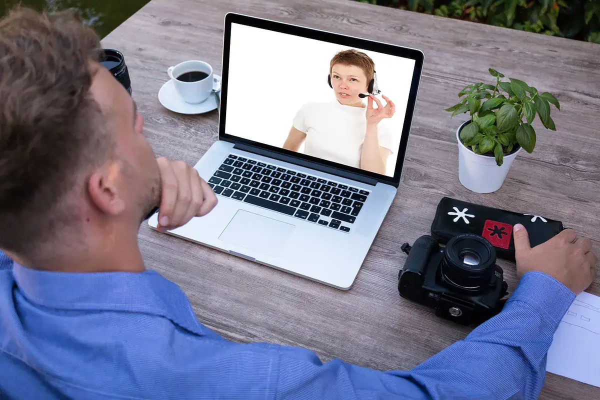 Cursist volgt een 1 op 1 theorieles online via een videoverbinding op een laptop