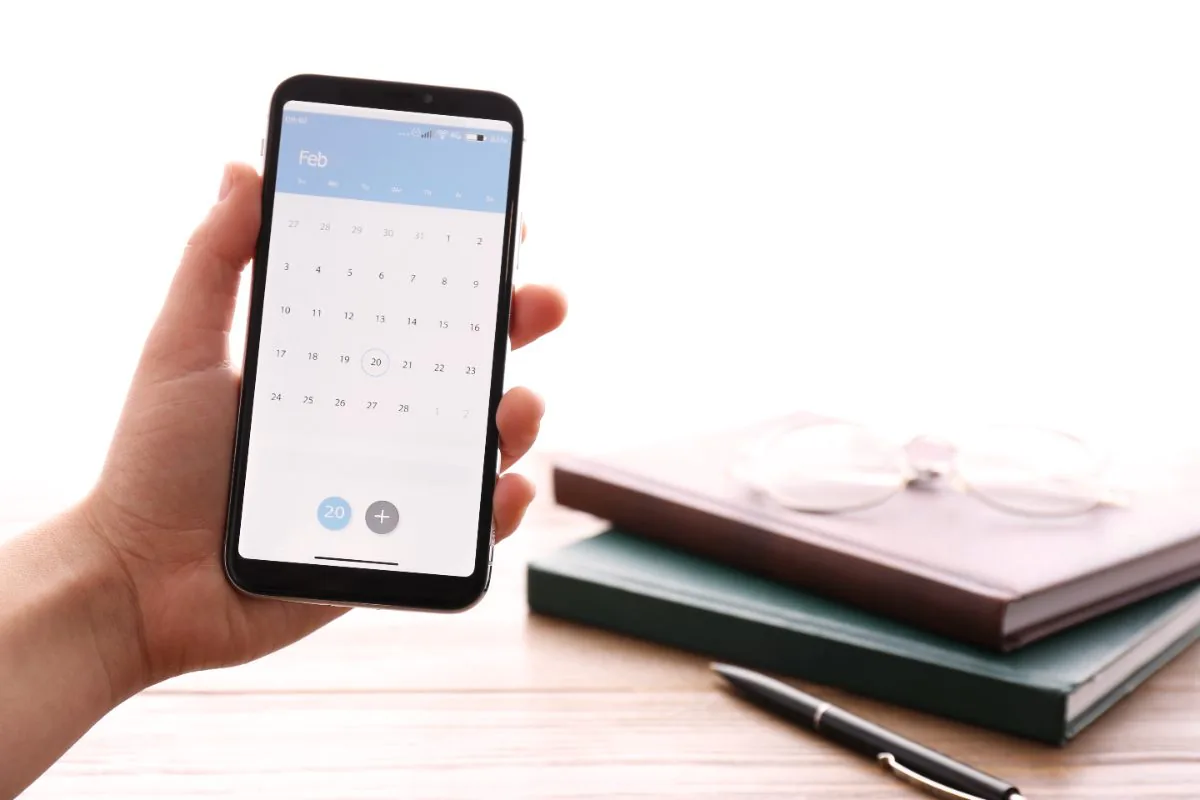 Telefoon met agenda-app naast boeken voor CBR theorie examen aanvragen