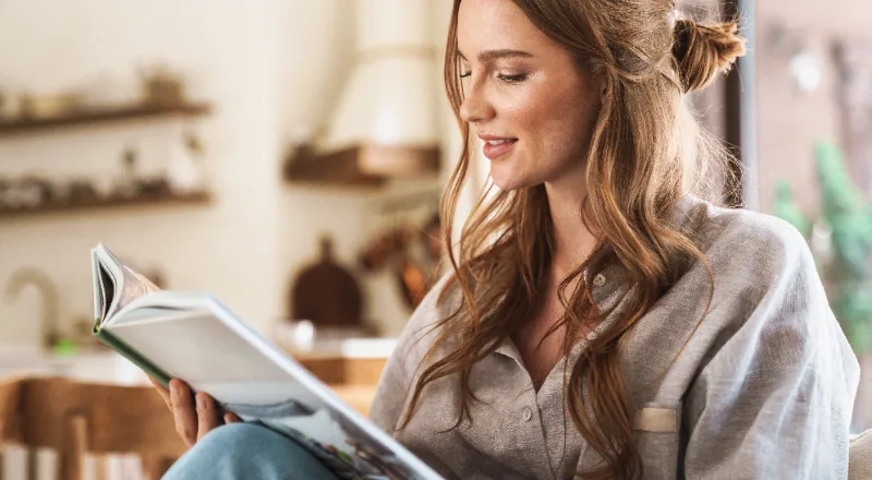 Vrouw studeert zelfstandig thuis met een boek