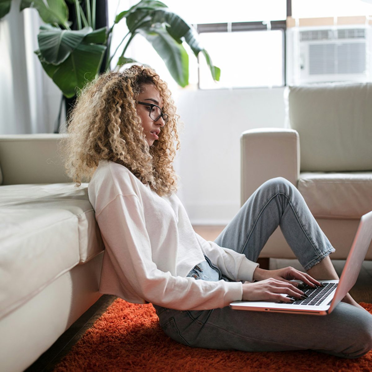 Vrouw met laptop op de vloer bereidt zich voor op mondeling theorie examen afleggen